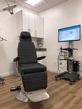 A treatment room with an ENT chair alongside an endoscopy tower and monitor